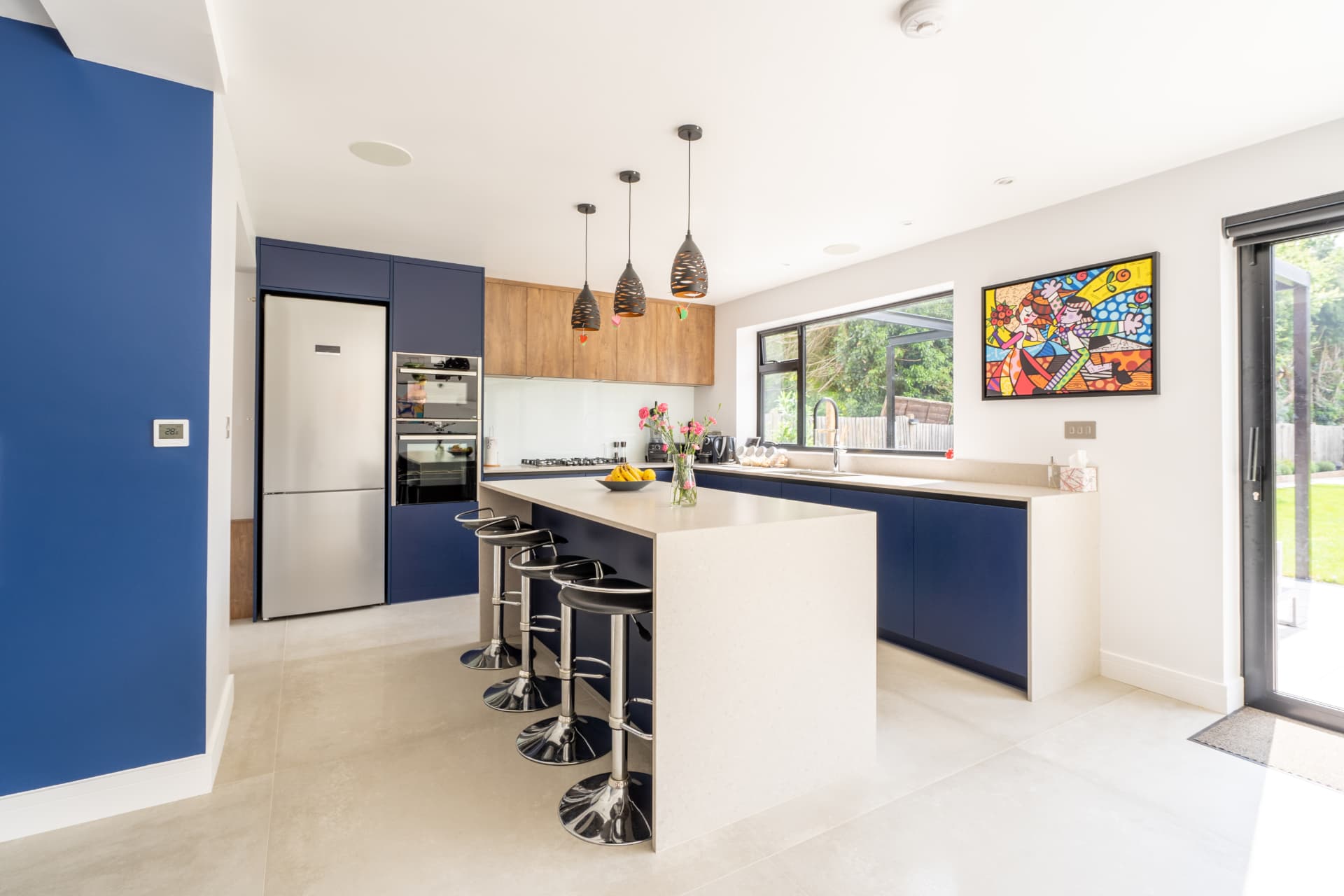 A finished open-plan kitchen with an island and garden doors